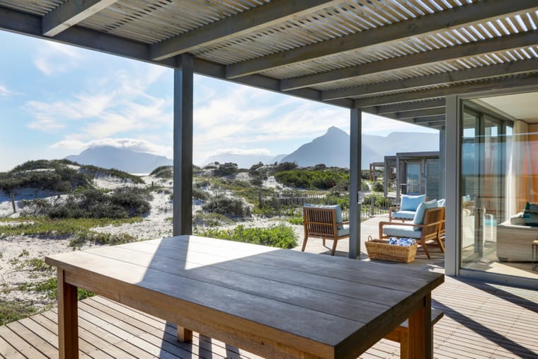 The outdoor dining table on the deck under the louvred roof