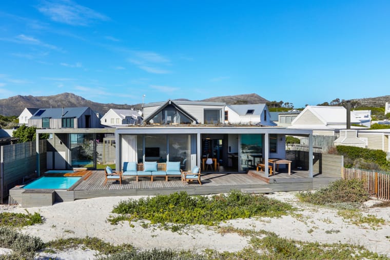 The house seen from the dune with the peninsula mountains rising behind it