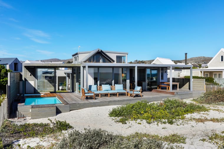The beach elevation of the house from the sand, with the deck and pool in front