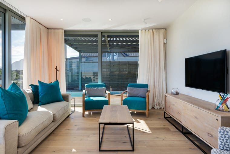 The living room seating with the pool and dune visible outside