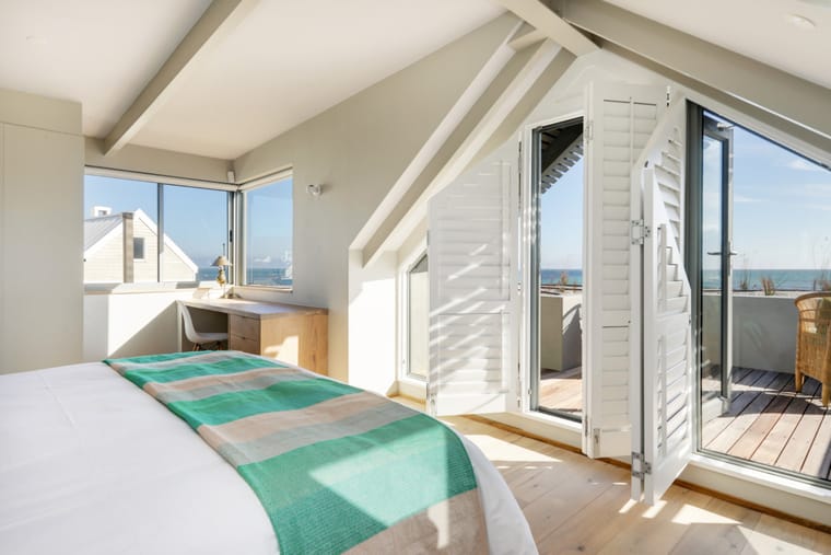 The master bed with doors open onto the small viewing deck